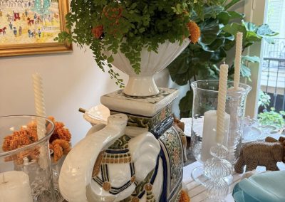 Blue and white equestrian-inspired tablescape with oversized floral arrangement and layered decor
