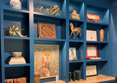 Blue built-in office shelving after styling with art, books, sculpture, and collected decor