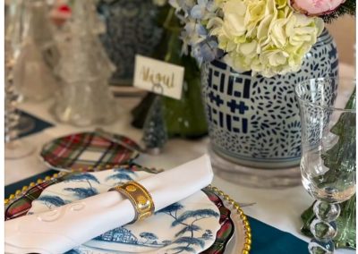Luxury blue floral place setting with layered china, gold accents, and hydrangea centerpiece