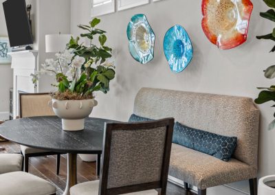 Breakfast nook with colorful wall plates, bench seating, and modern chandelier