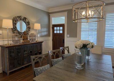 Dining room after refresh with statement chandelier, styled sideboard, floral centerpiece, and layered seating