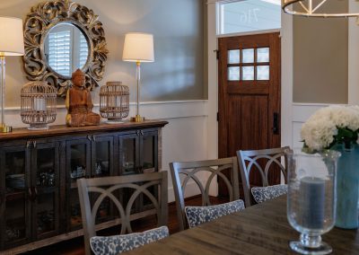 Dining room with carved mirror, console table, wood chairs, and soft table lighting
