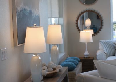 Elegant entryway and living room styling with designer lighting, layered mirrors, and soft neutral decor