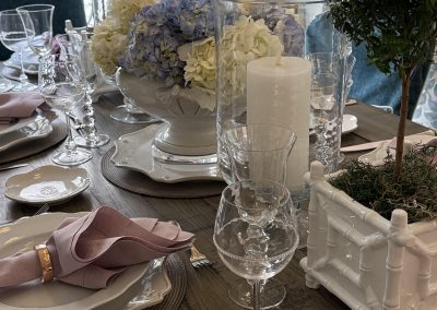 Elegant dining table styling with hydrangeas, blush linens, crystal stemware, and candles