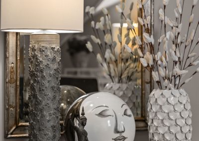 Entryway console table with mirror, table lamp, patterned vase, and decorative accents