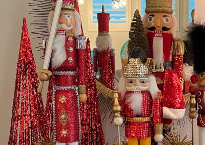 Christmas entry table with nutcrackers, red cone trees, ornaments, and festive holiday decor