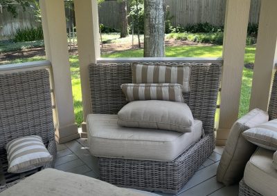 Outdoor patio seating area before redesign with worn neutral cushions and unfinished styling