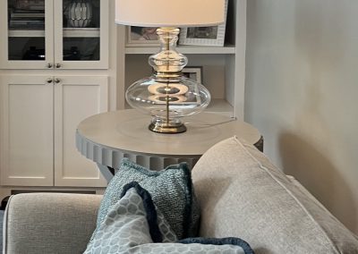 Small stairway sitting area with blue pillows, white cabinetry, and decorative accents