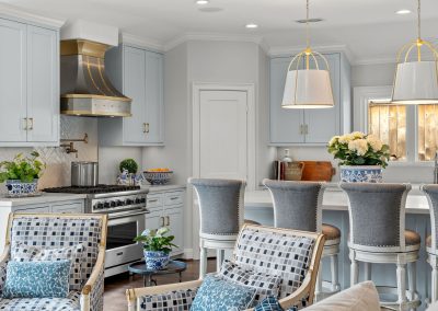 White kitchen with island seating and adjacent living room with blue patterned accents