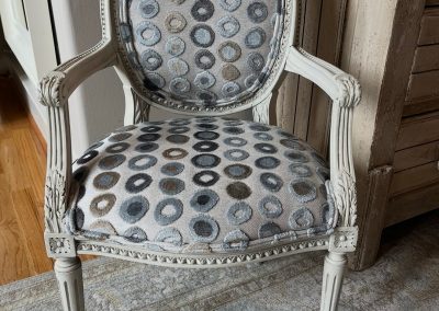 Vintage armchair after refresh with painted frame and gray circular patterned upholstery