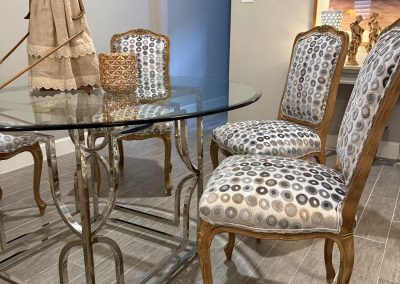 Carved dining chairs after refresh with circular patterned upholstery and glass dining table